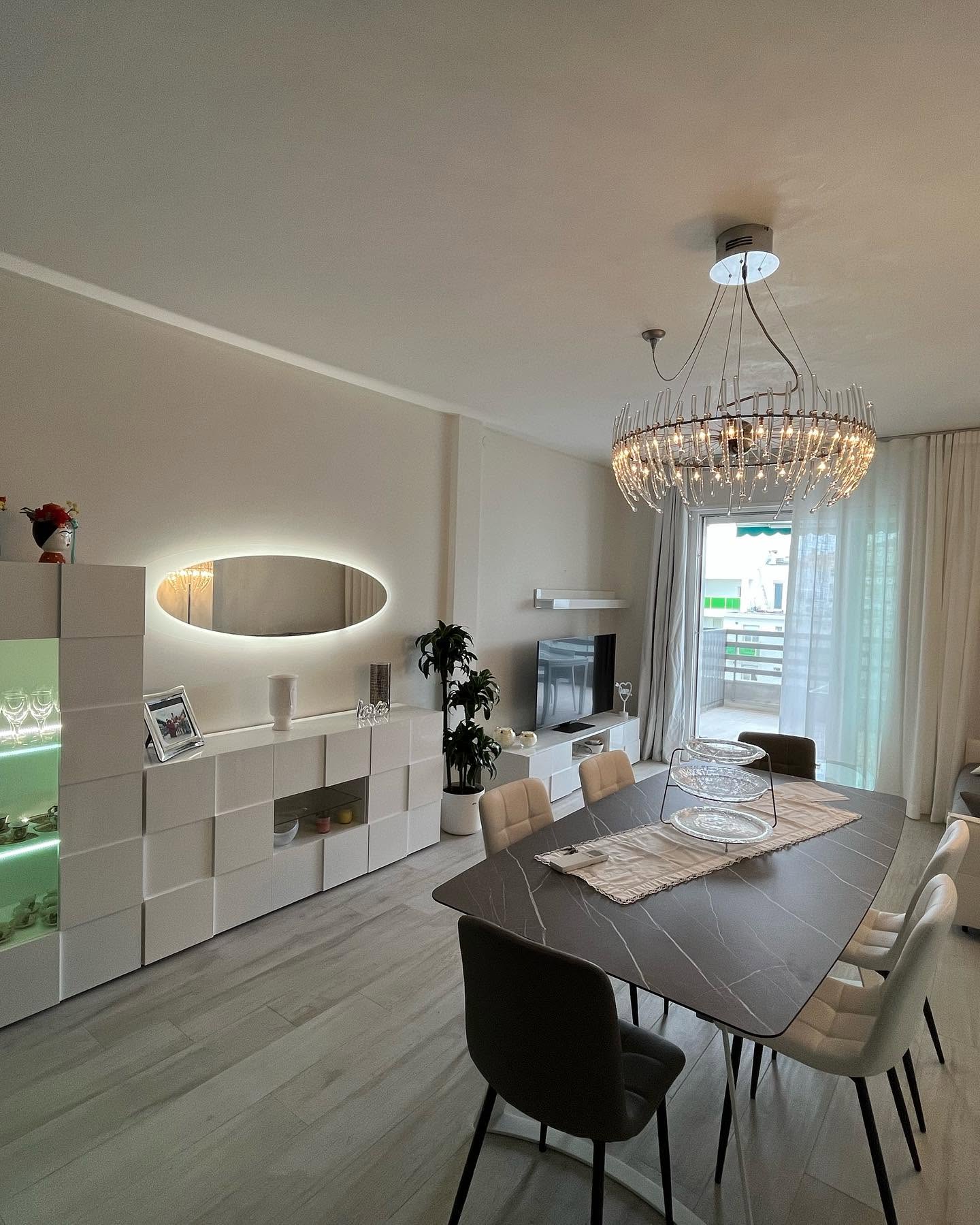 Illuminazione decorativa di soggiorno con lampadario e specchio retroilluminato